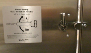 Toilet flush options sticker too close to stall locking mechanism